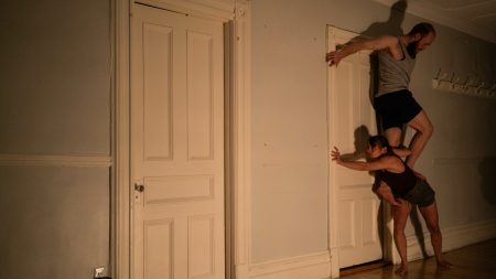 Un homme et une femme présentent un spectacle de cirque dans le corridor d'un appartement.