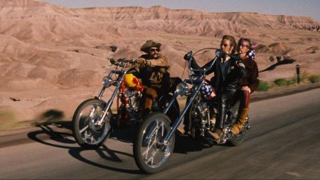 Image du film Easy Rider. Deux motos roulent sur une route désertique.