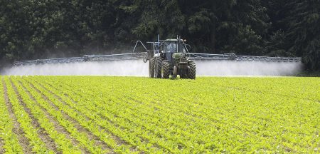 Un tracteur épand un produit dans un champ