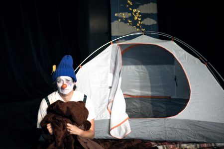Un clown devant une tente